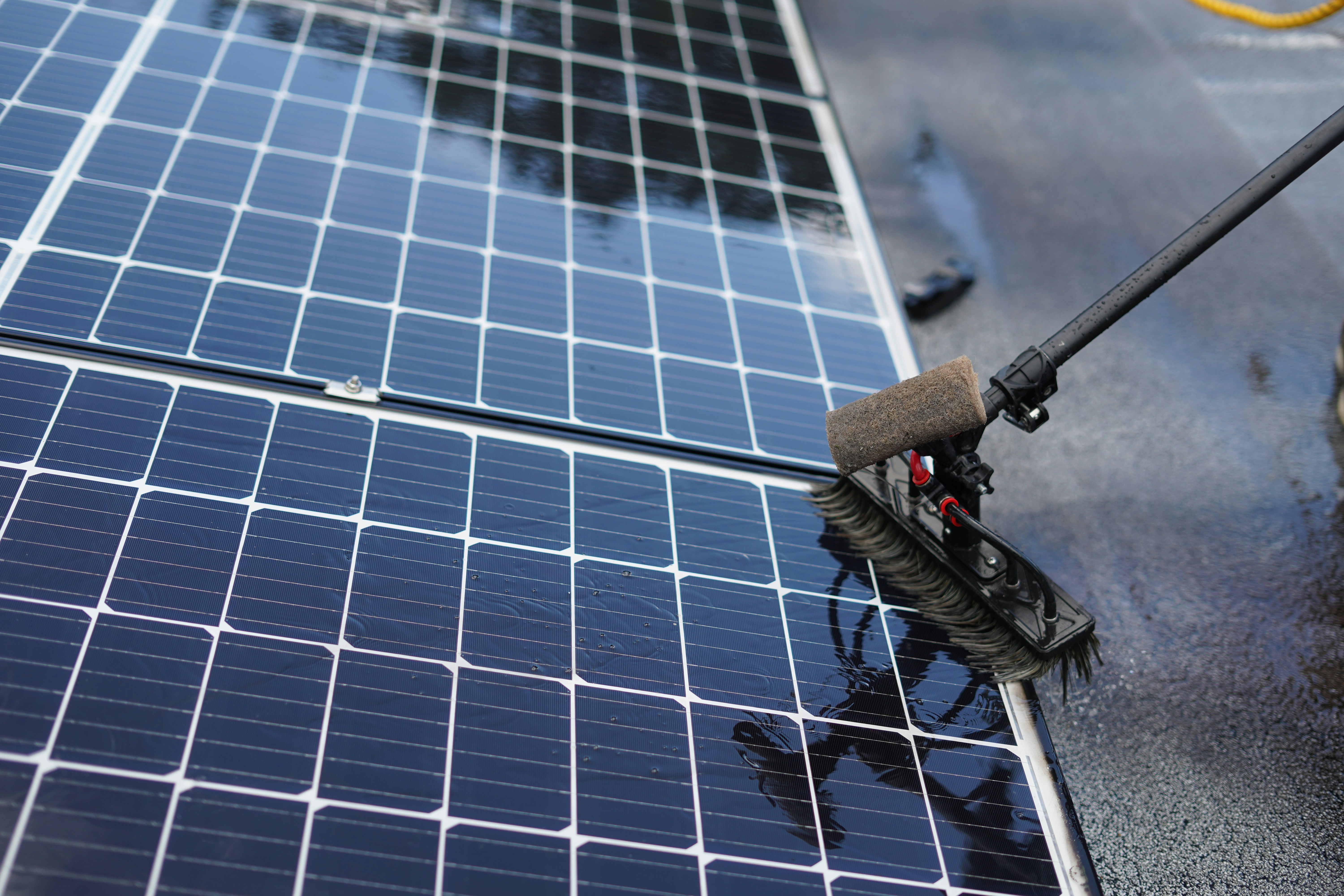Solar panel being washed with a soft brush